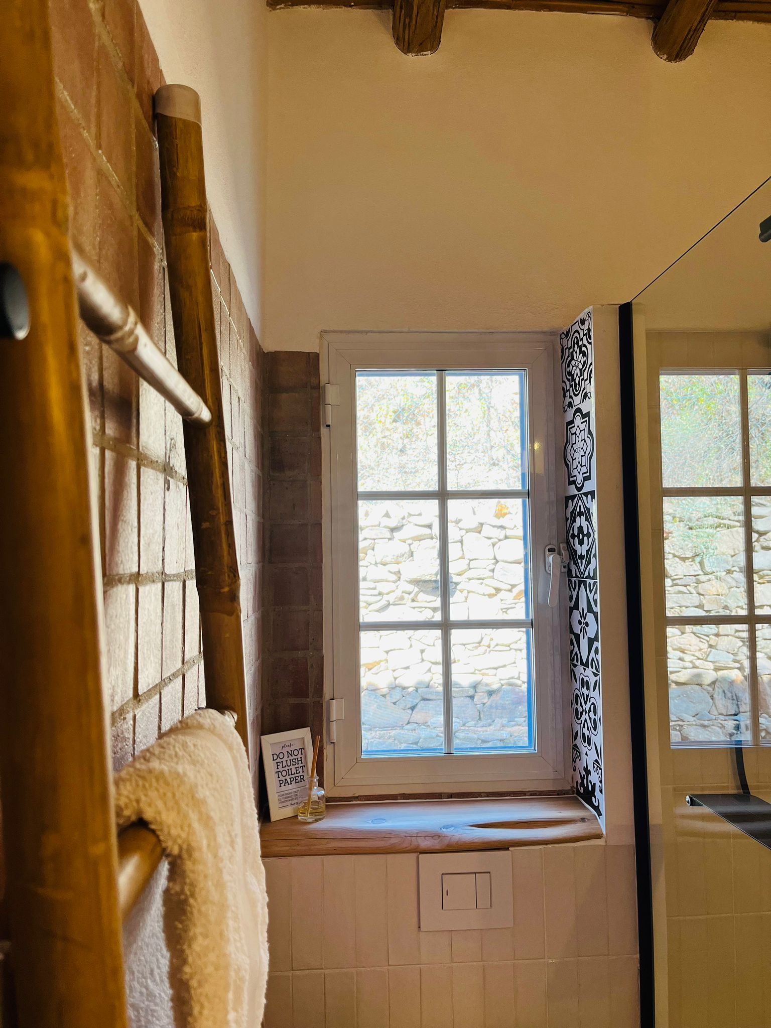 Ein Badezimmer mit Fenster und Handtuchhalter