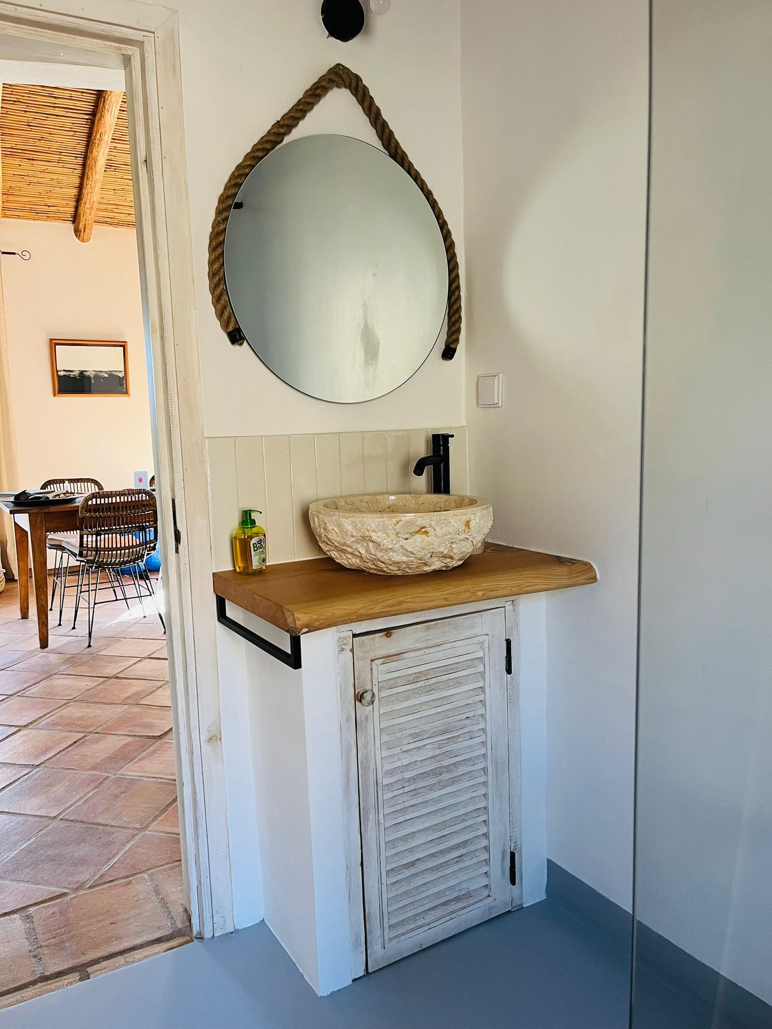 Ein Badezimmer mit Waschbecken und Spiegel an der Wand.