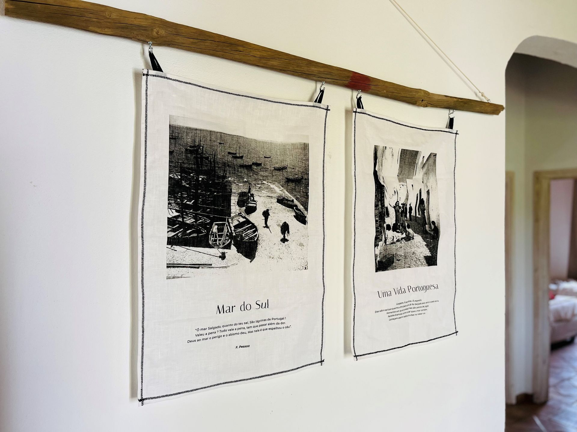 An einer weißen Wand hängen zwei Schwarzweißbilder.