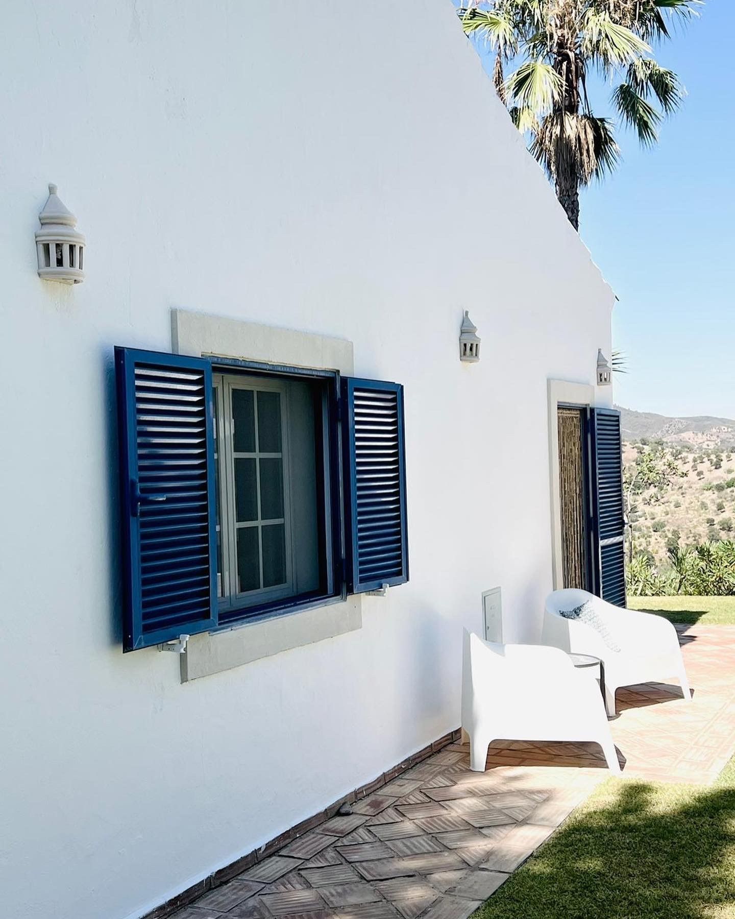 Ein weißes Haus mit blauen Fensterläden