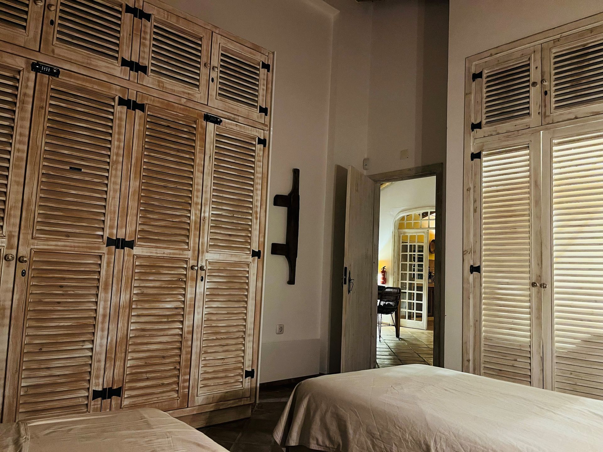 Een slaapkamer met twee bedden en veel houten luiken