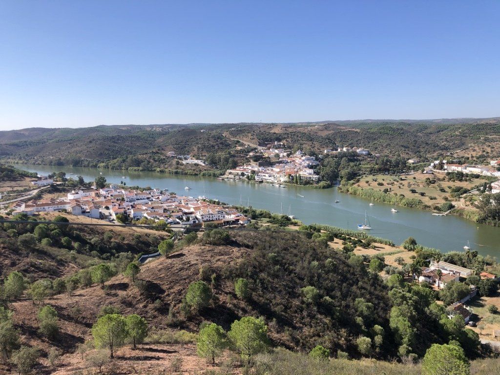 Uma vista aérea de um rio cercado por árvores e casas.