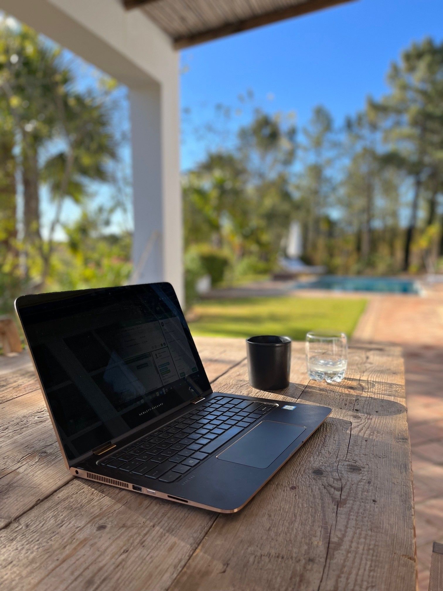 Er staat een laptop op een houten tafel.
