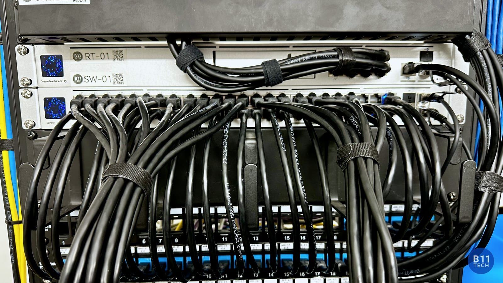 Real B11 Tech structured cabling installation with organized black patch cables and labeled rack equipment