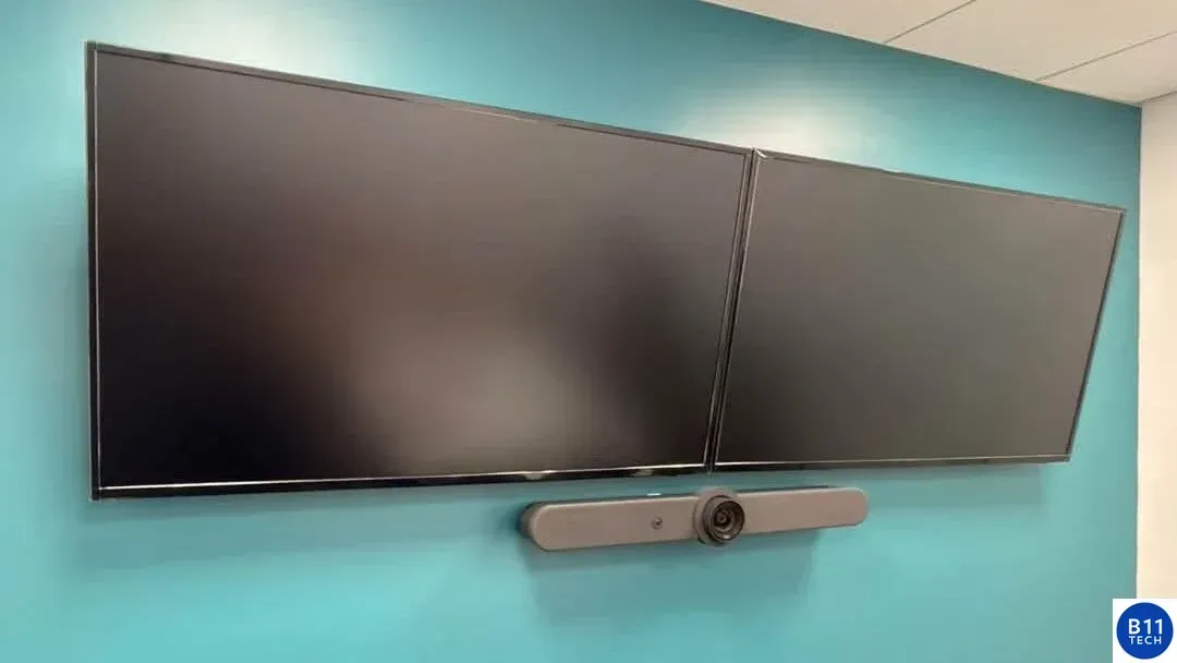 Real B11 Tech conference room installation with two wall-mounted displays and a video conferencing bar.