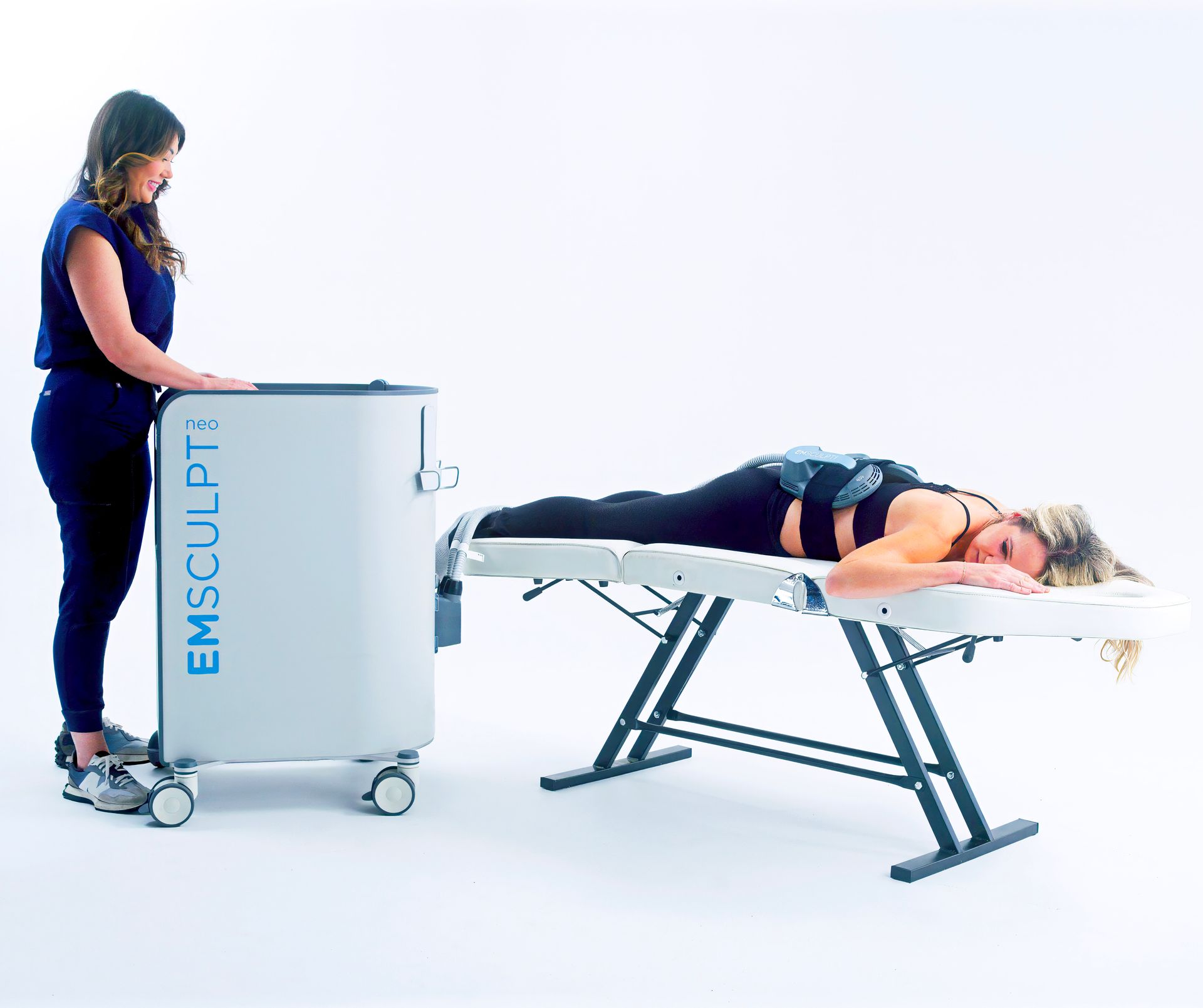 Patient lying down receiving an Emsculpt Neo body contouring treatment