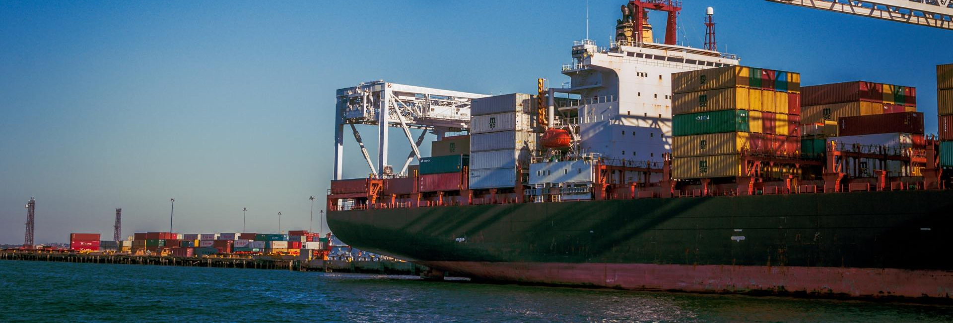 A large container ship is floating on top of a body of water.