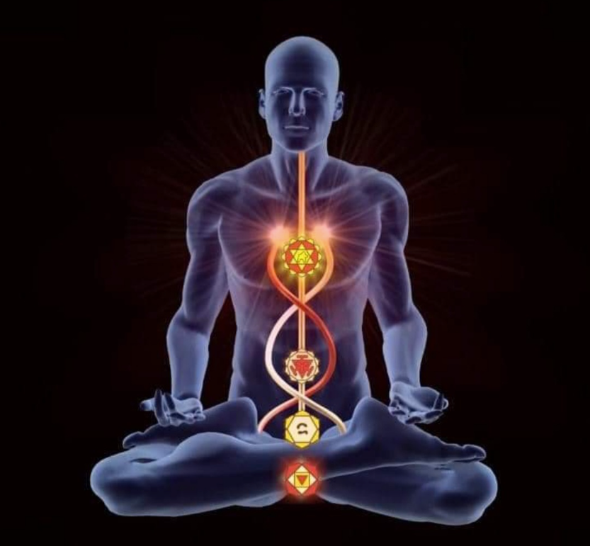 A man is sitting in a lotus position with his chakras glowing