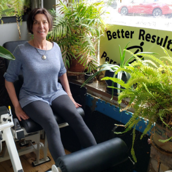 A woman is sitting in front of a sign that says better results