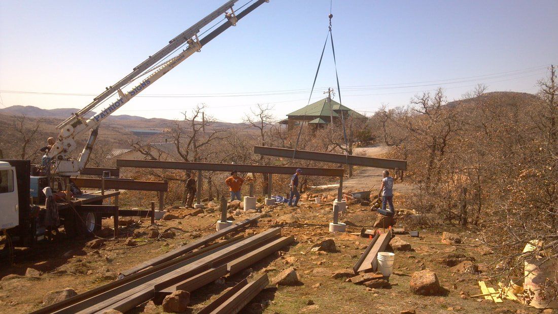 A crane is lifting a wooden structure in a field.