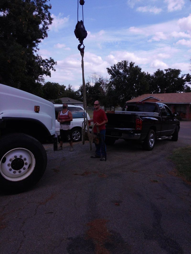A man in a red shirt is standing next to a truck