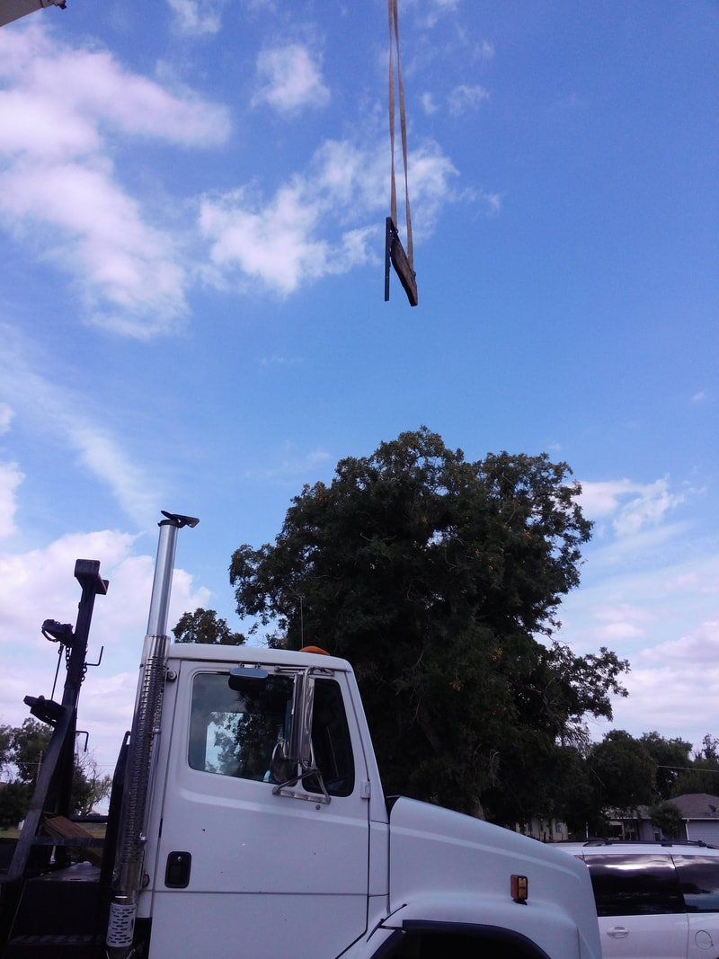 A white truck with a crane attached to it