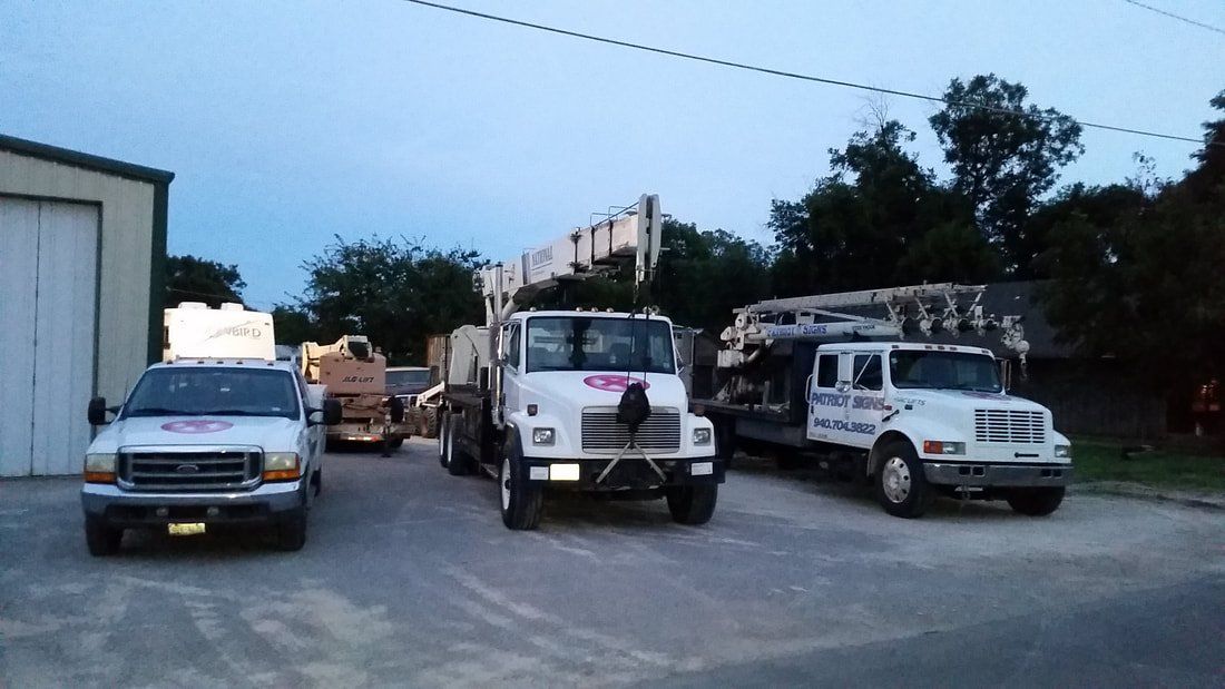 Three trucks are parked in front of a garage.
