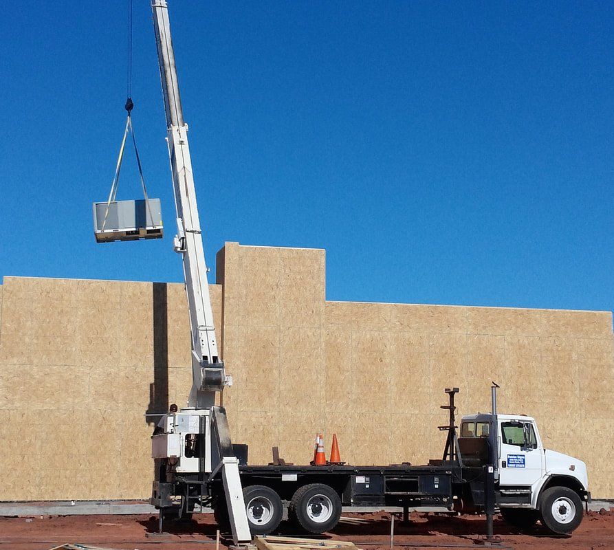 A white truck with a crane attached to the back of it