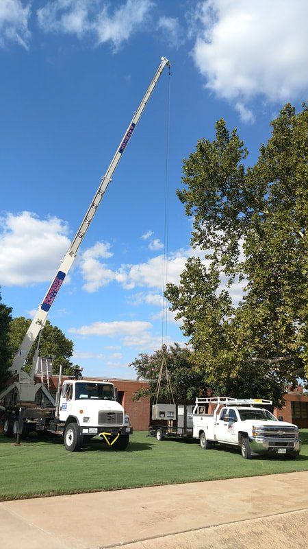 A truck with a crane on top of it is parked next to a truck.