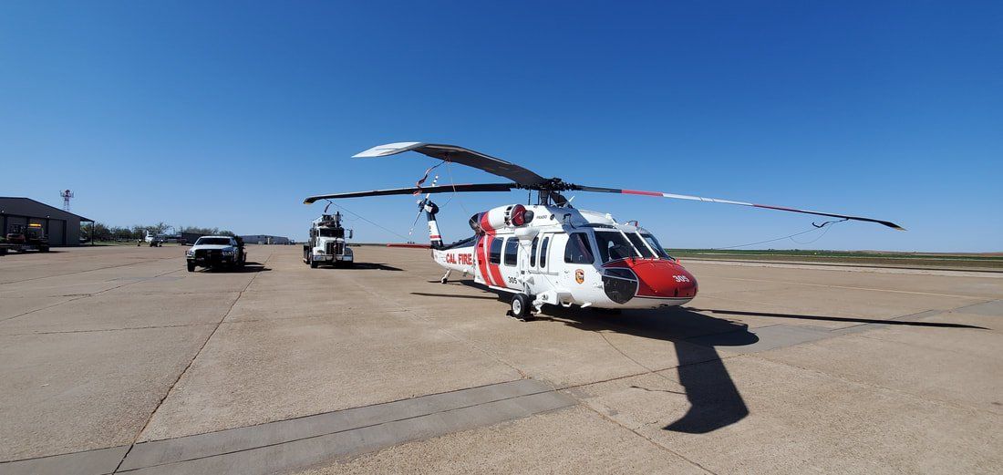 A red and white helicopter is parked on a runway