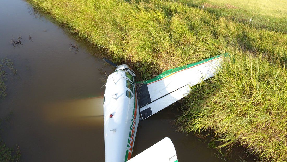 An aerial view of a plane that has crashed into a body of water.