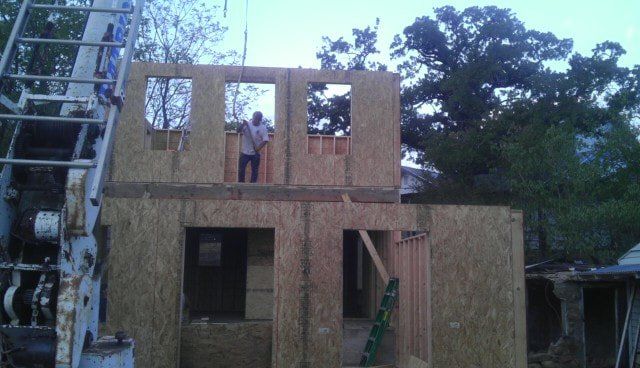 A man is standing on the second floor of a house under construction.