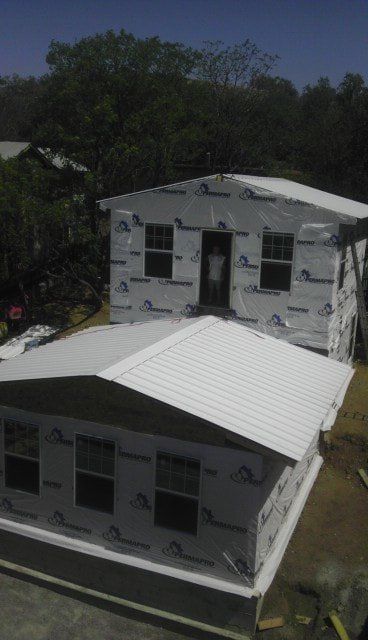 A house with a white roof is being built