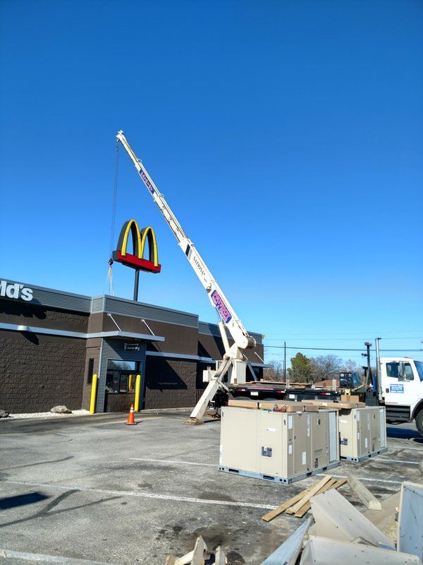 A large mcdonald 's sign is being lifted by a crane