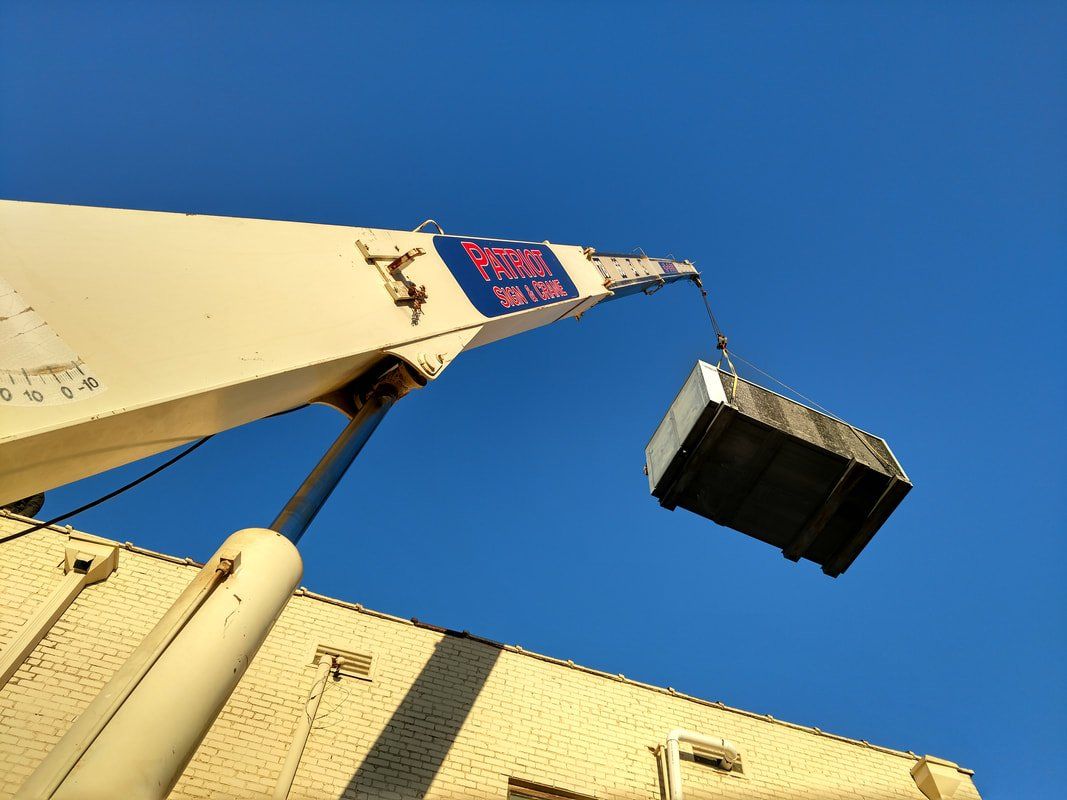 A crane is lifting a container into the air