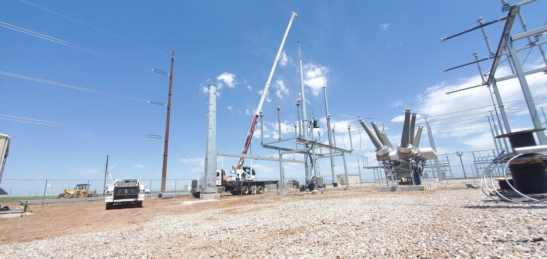 A blurred image of a construction site with a blue sky in the background.