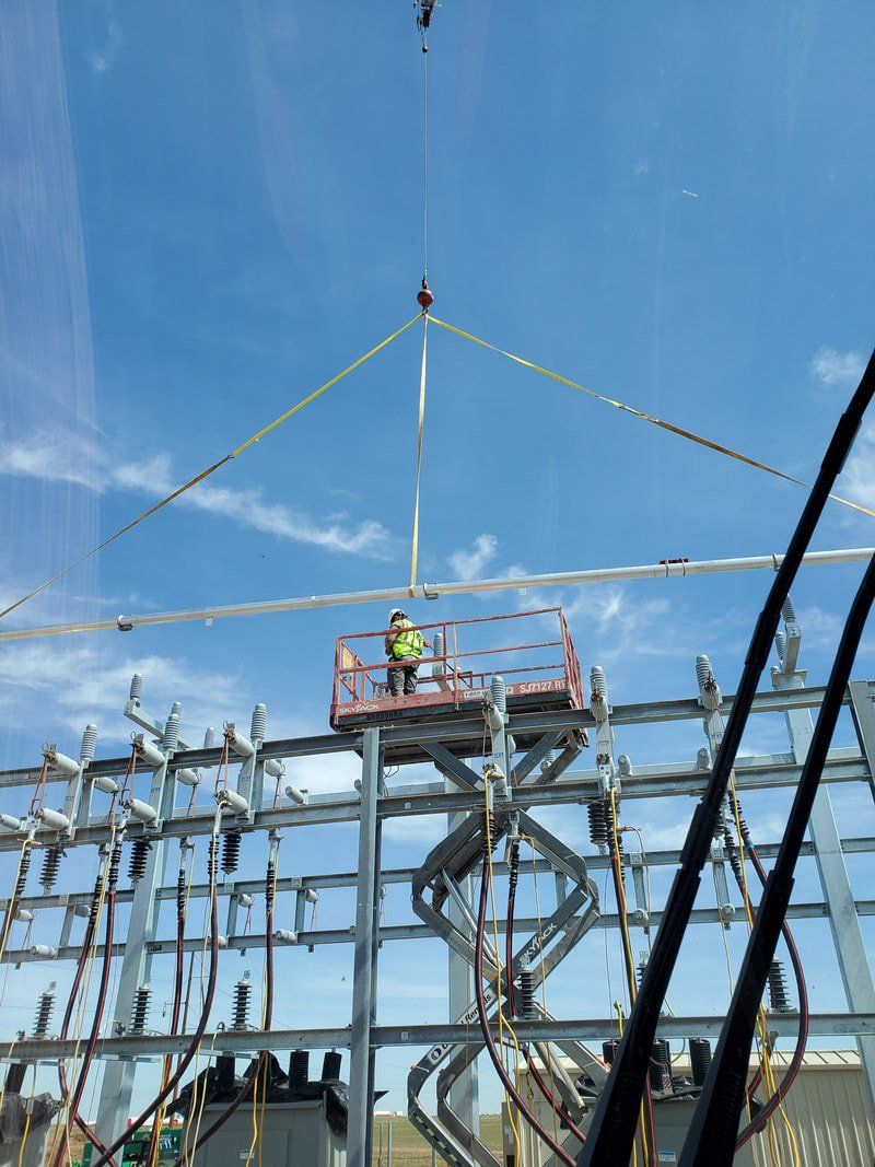 A crane is lifting a metal structure on a construction site.