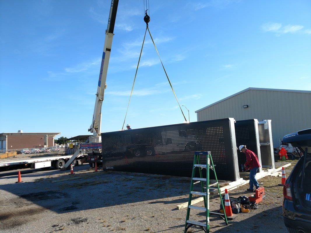 A crane is lifting a large container in a parking lot.