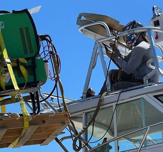 A man wearing a helmet is working on a boat