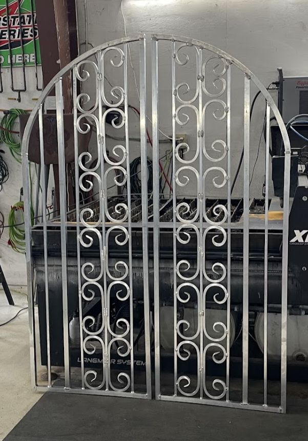 A pair of stainless steel gates are sitting in a garage.