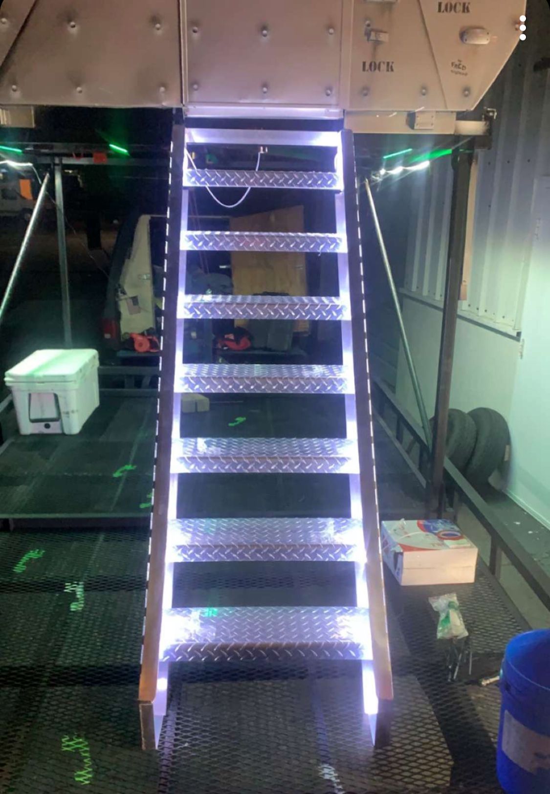 A ladder with lights on the steps is in a room.