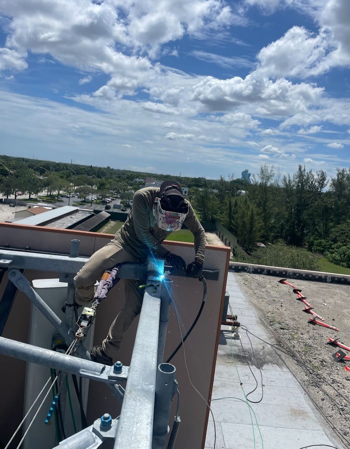 A man is welding on the side of a building.