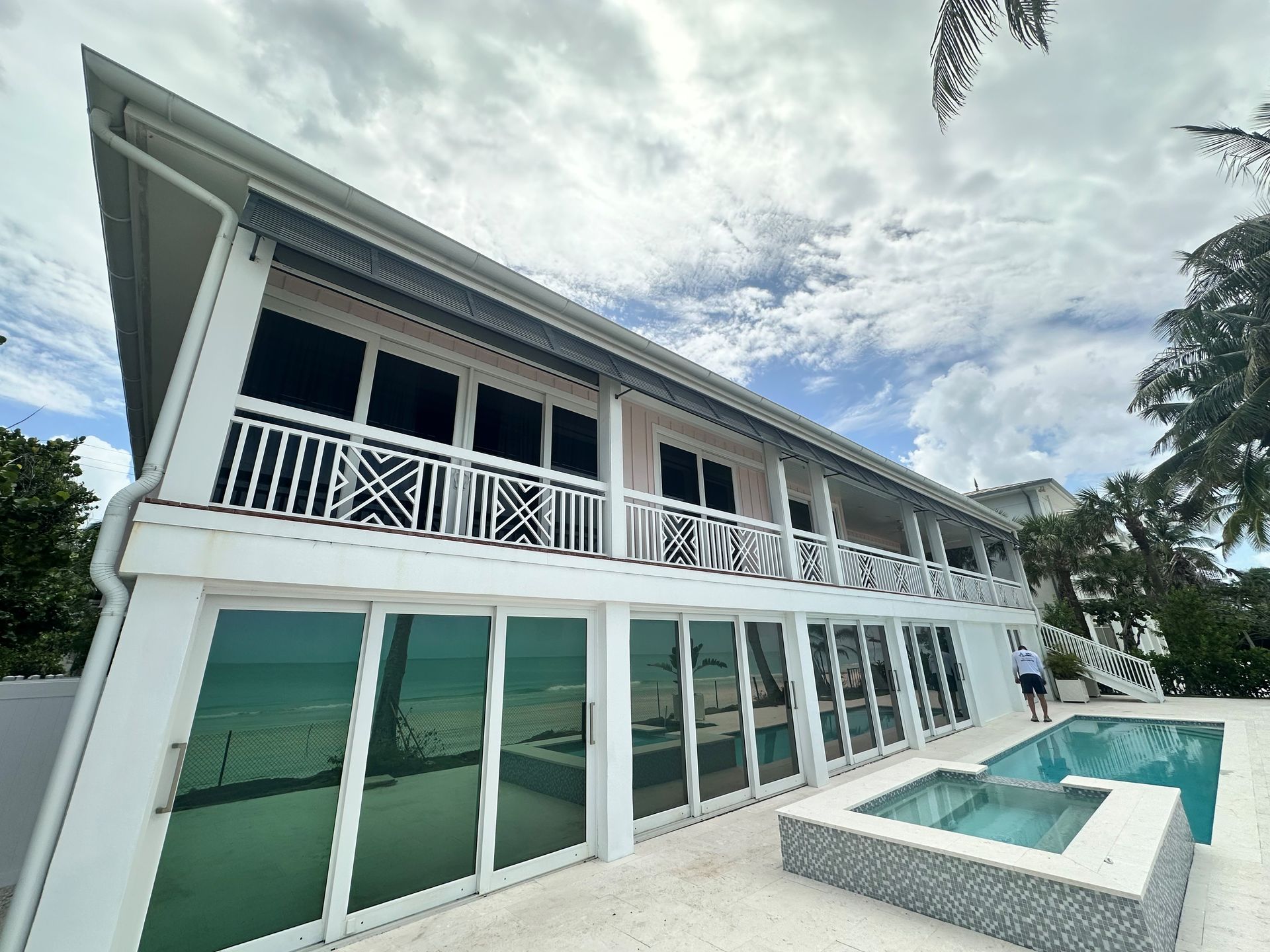 A large white house with a swimming pool in front of it.