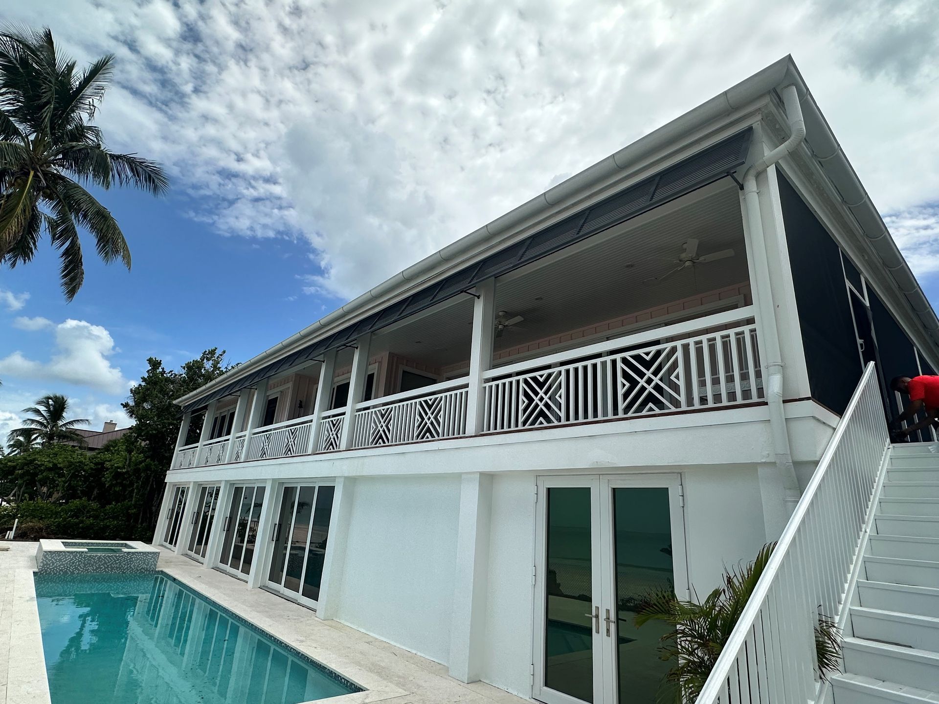 A large white house with a swimming pool in front of it.