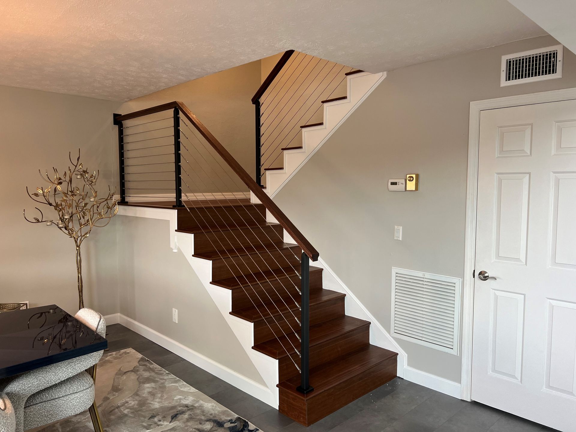 A living room with stairs leading up to the second floor