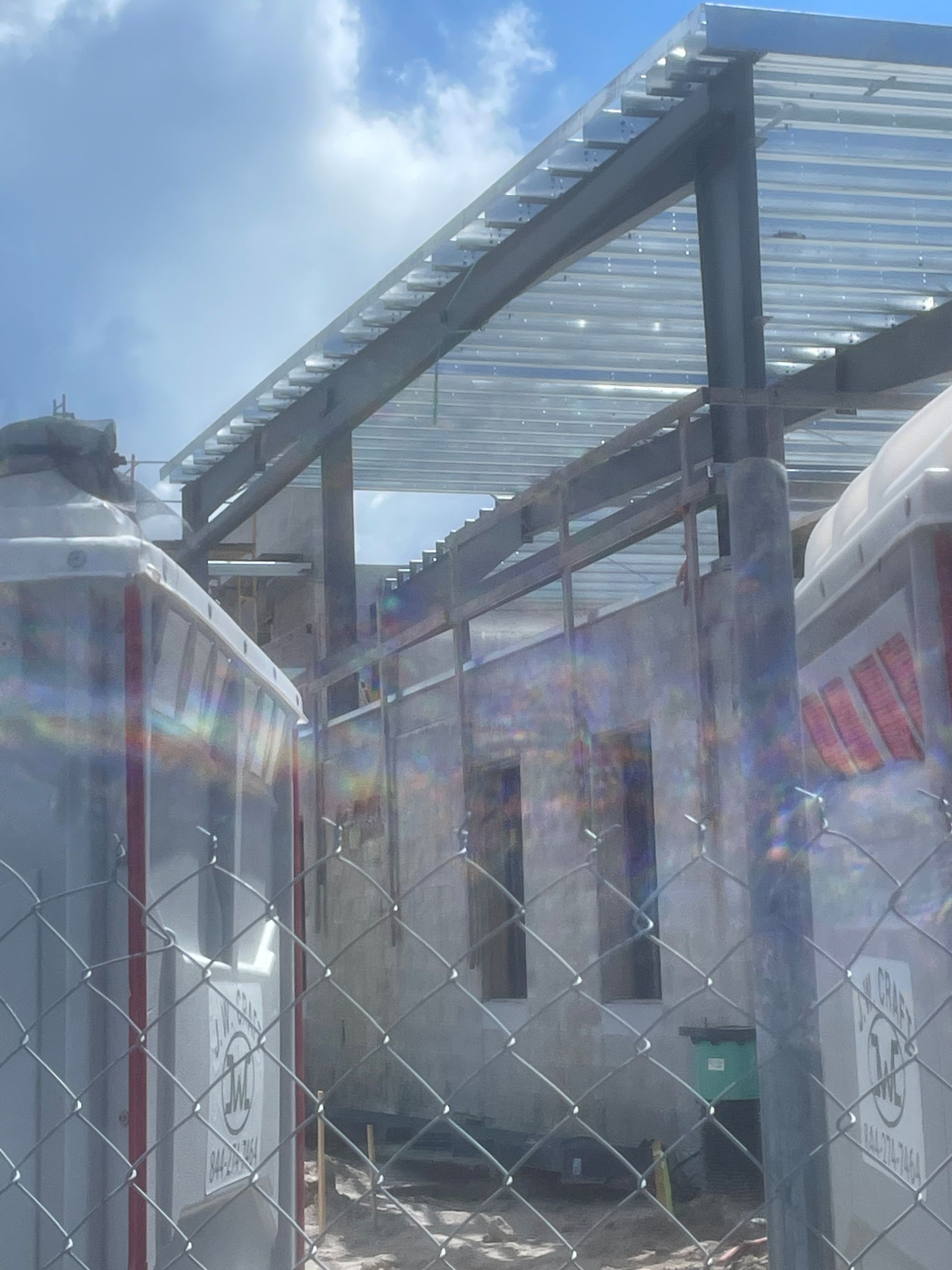 A chain link fence surrounds a building under construction