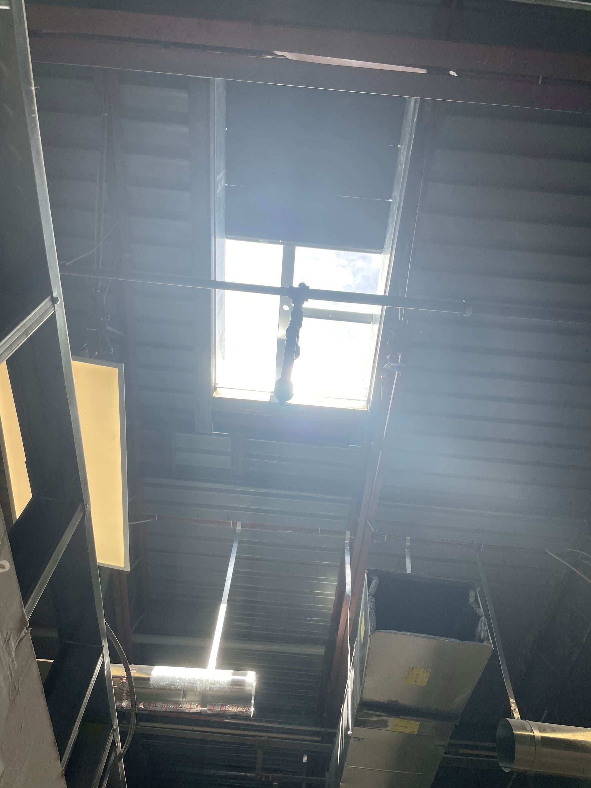 The sun is shining through a window in the ceiling of a building.