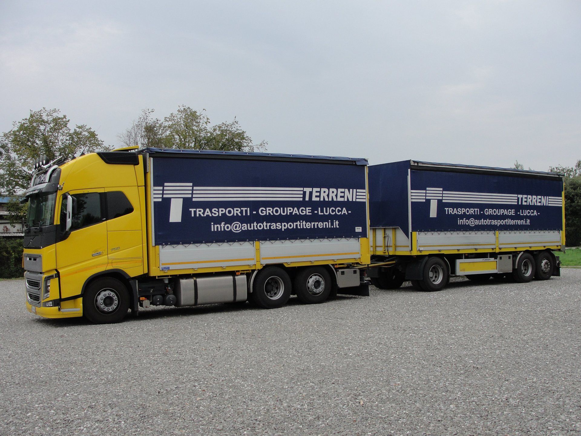 Un autoarticolato giallo con container blu scuro recanti la scritta 