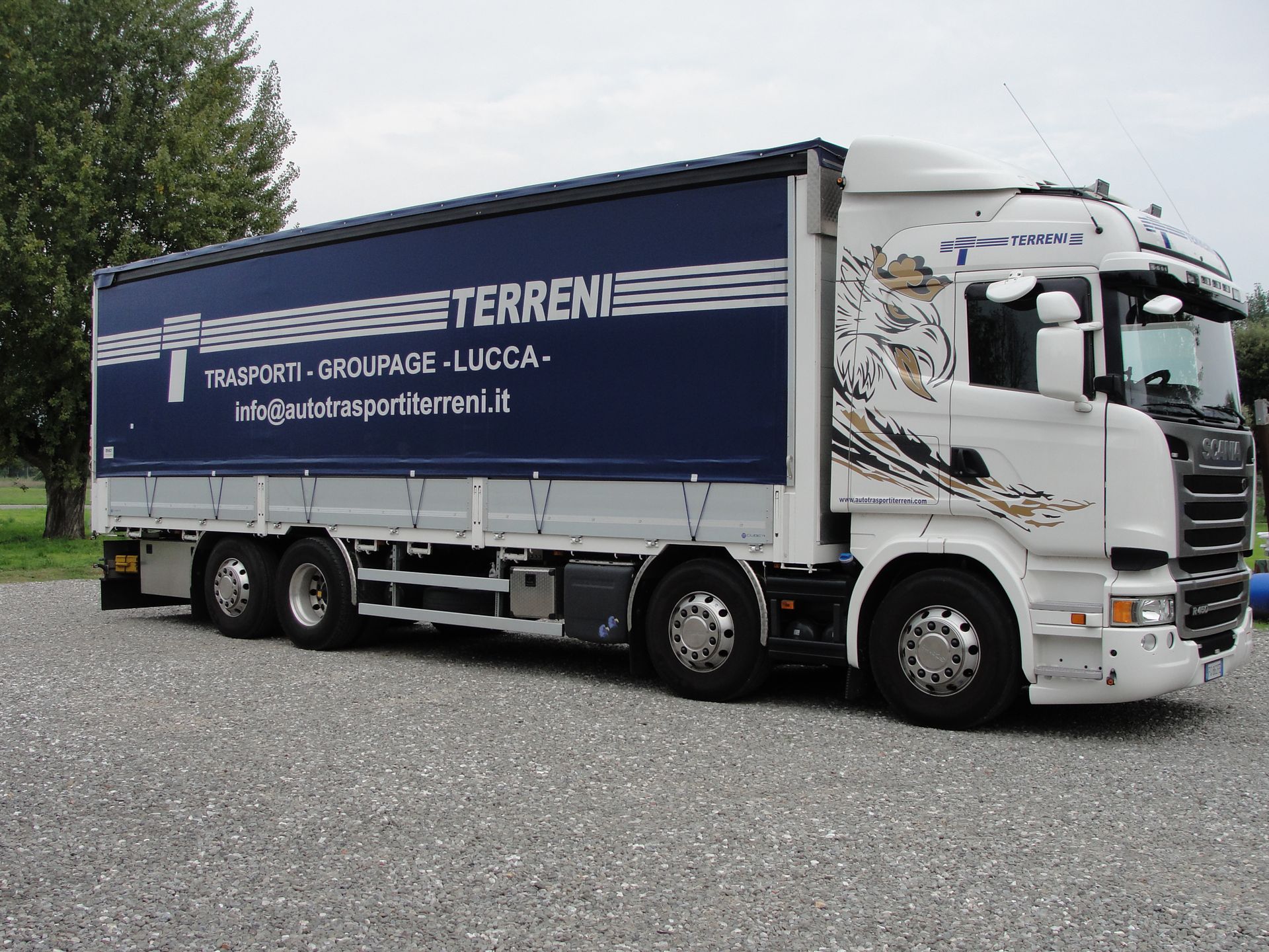Un semirimorchio Scania bianco con rimorchio blu con la scritta 
