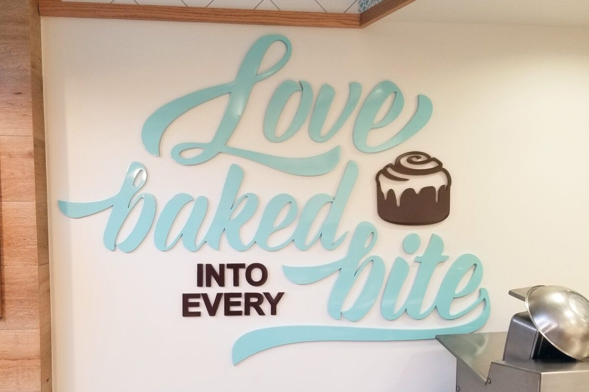 Laser-cut acrylic wall sign with script lettering for Love Baked Bite bakery