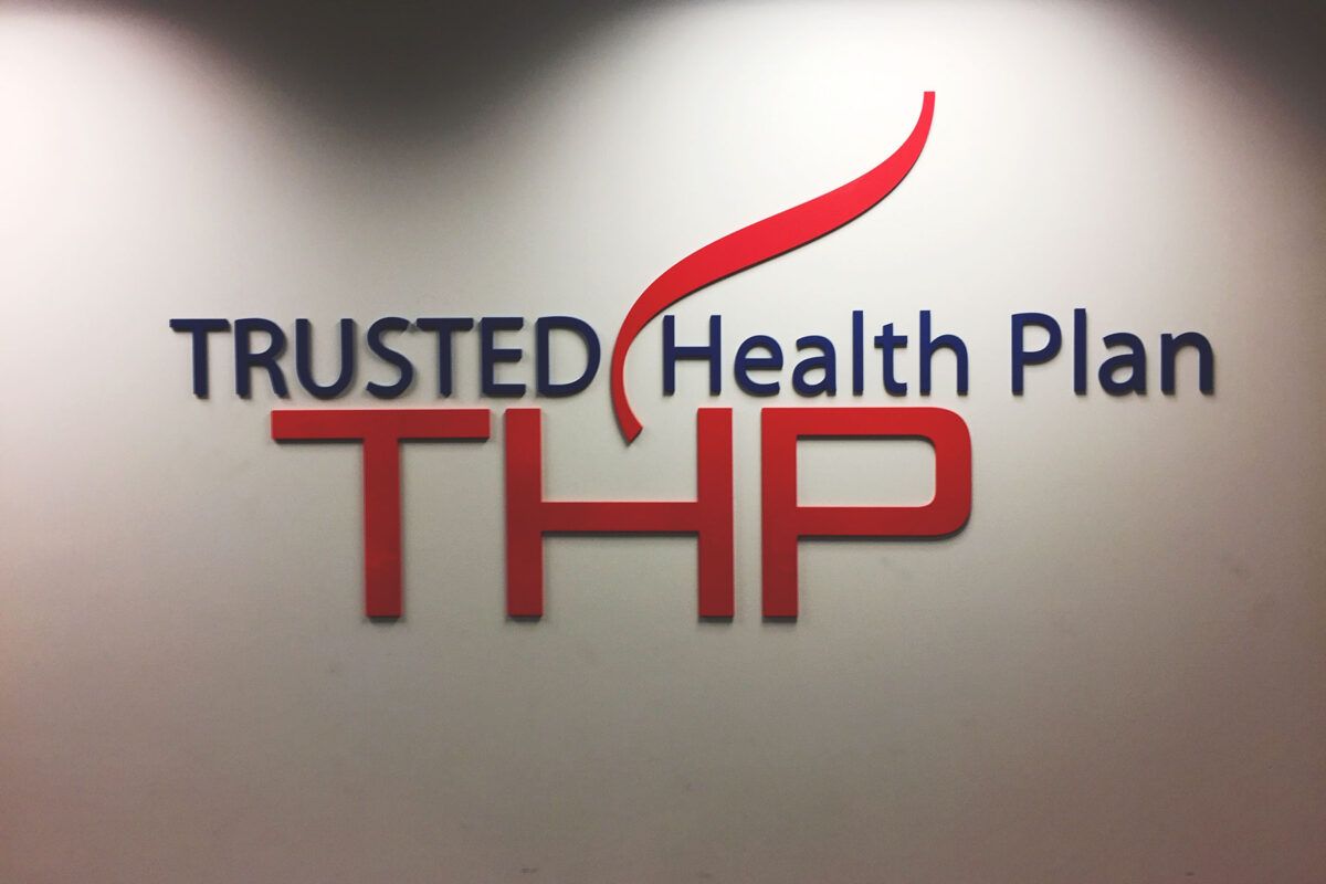 Dimensional THP Trusted Health Plan lobby sign with red accent lettering