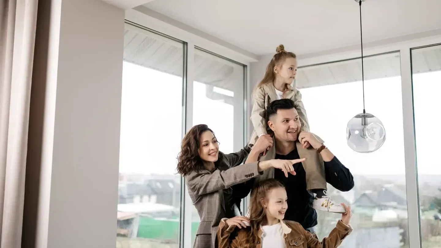 A family is taking a picture of themselves in their new home.