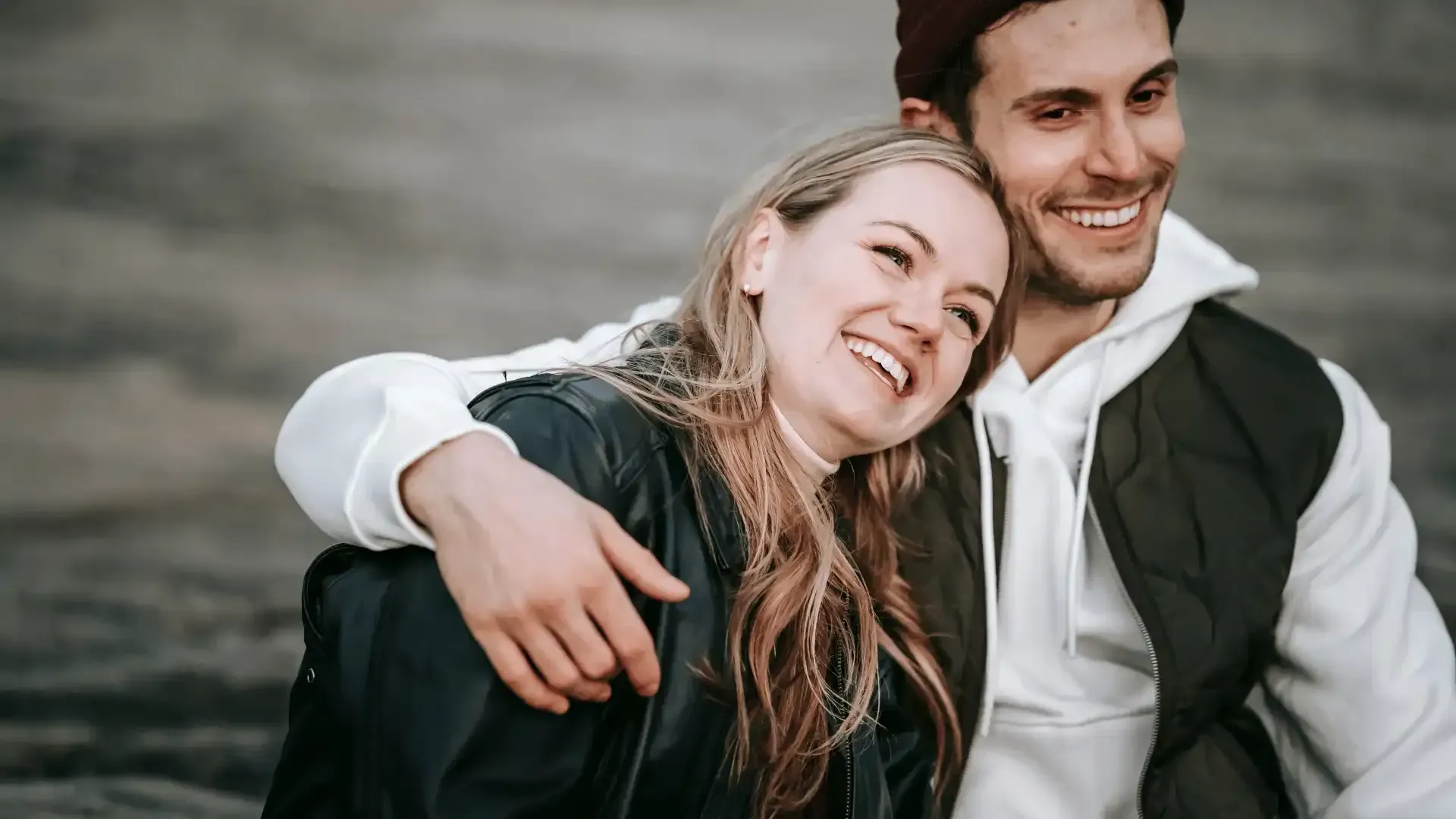 A man and a woman are sitting next to each other and smiling.