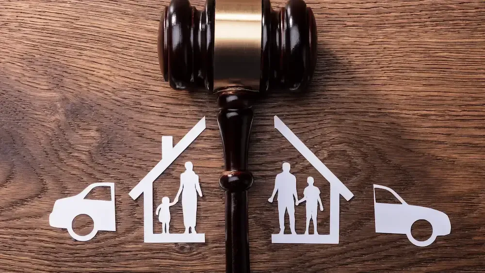 A wooden judge 's gavel with a family , car , and house cut out of it.