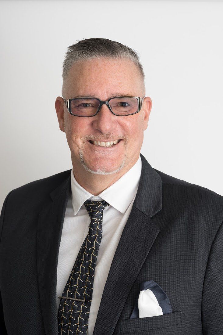 a man in a suit and tie is smiling for the camera .