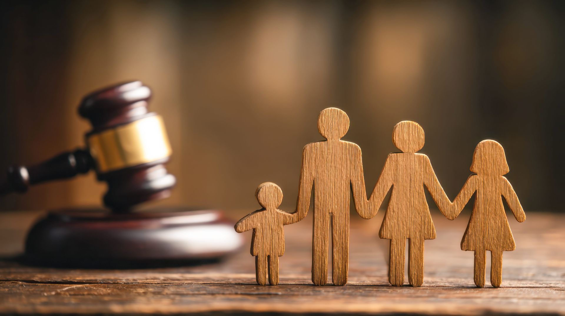 Wooden family figures beside a gavel, symbolizing family law or custody decisions