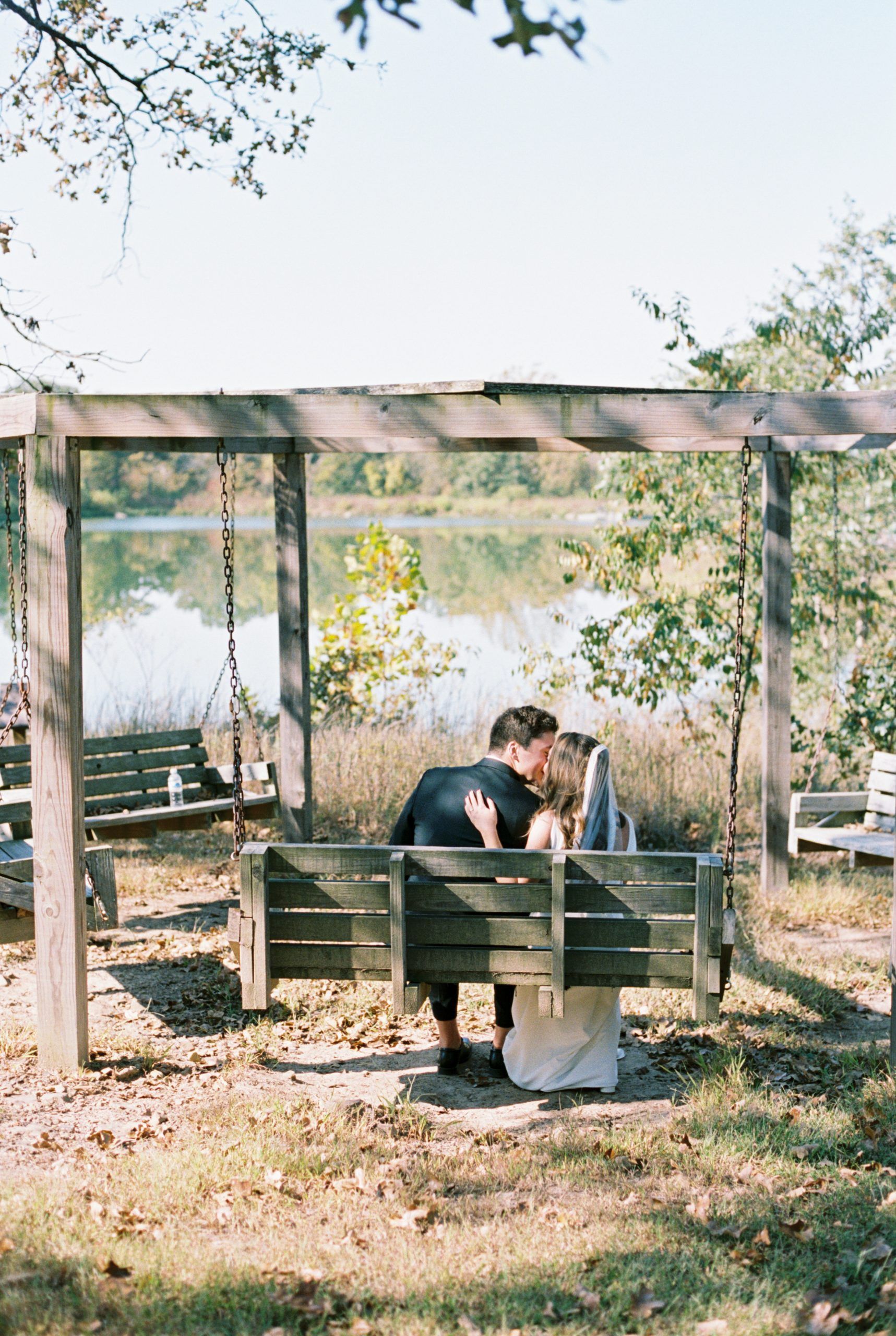 wedding kiss by the lake at Camp Loughridge in Tulsa Oklahoma