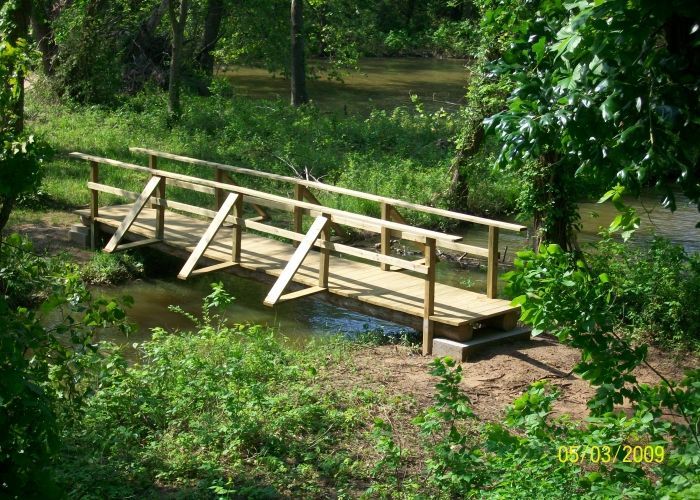 A small wooden bridge over a river in the woods