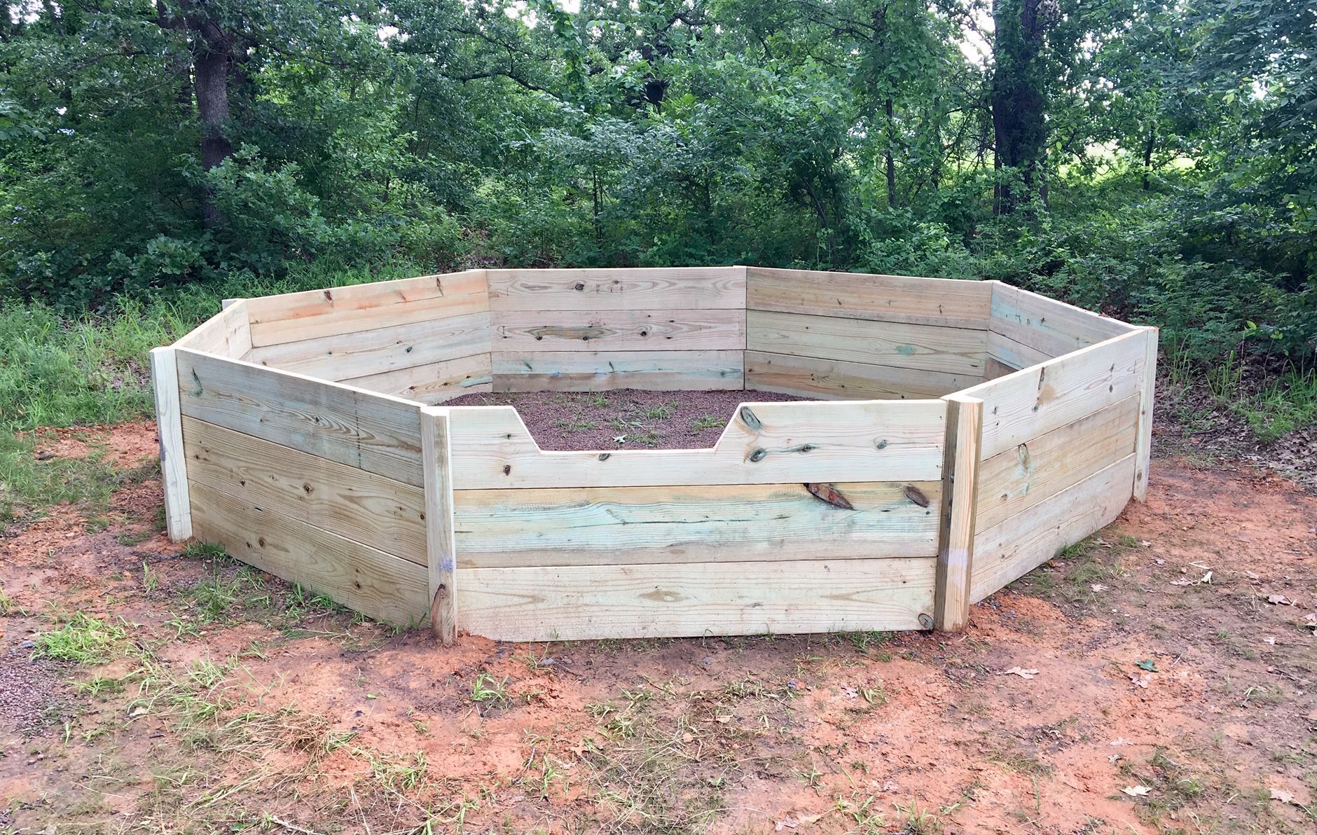 A wooden fence is sitting on top of a dirt field.