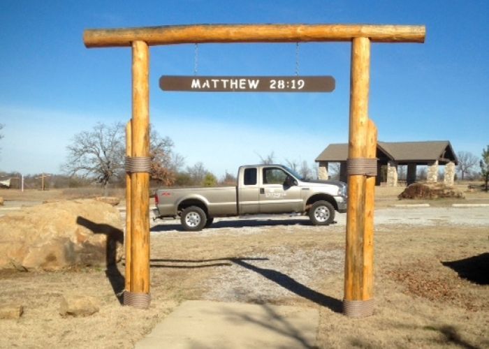 A truck is parked under a sign that says matthew 28 19